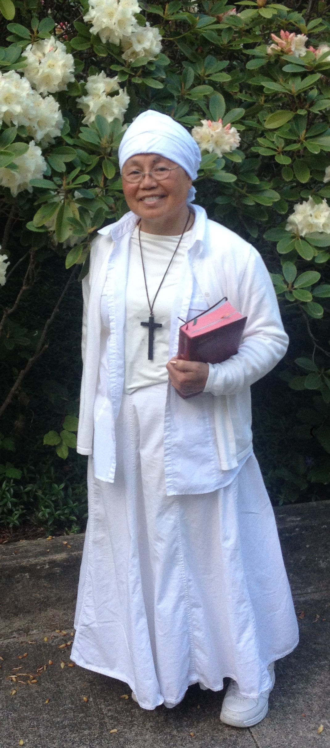 Sister Rose standing in front of white flowers